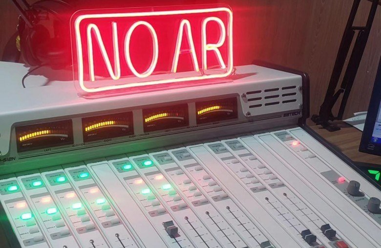 Mesa de som de rádio com sinal luminoso indicando no ar.