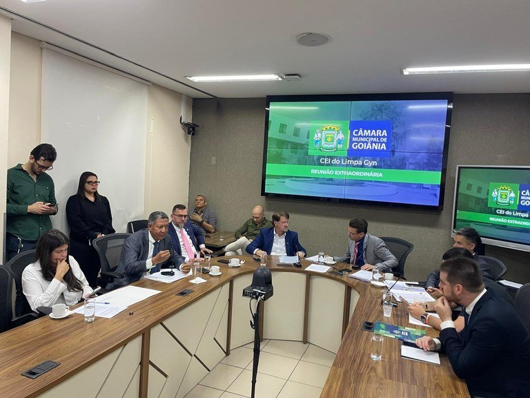 Integrantes da comissão se reúnem em torno de mesa na Câmara Municipal.
