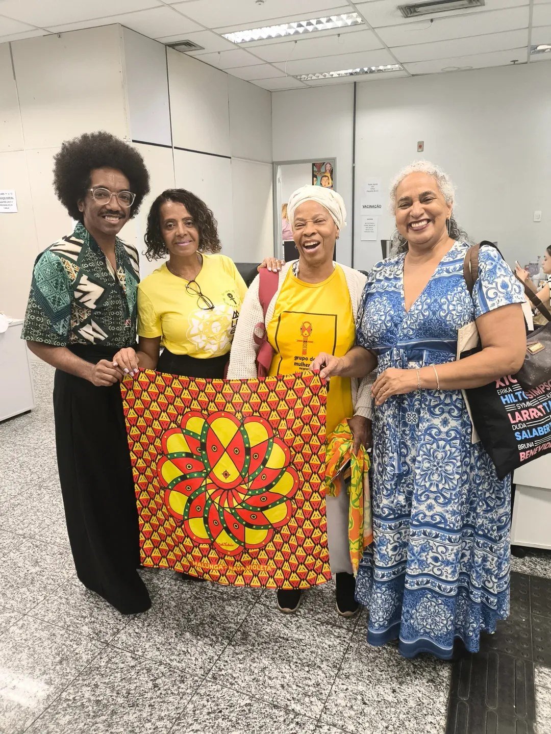 Participantes do mutirão posam com um tecido estampado do Grupo Malunga